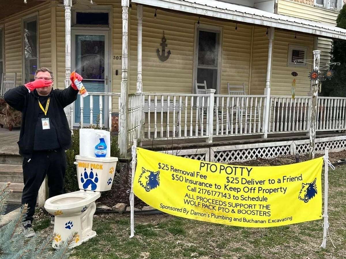 Pleasant Hill resident Andy Webb poses with the "PTO Potty," a fundraising effort by Wolf Pack PTO that leaves a decorated toilet in people's front yards.