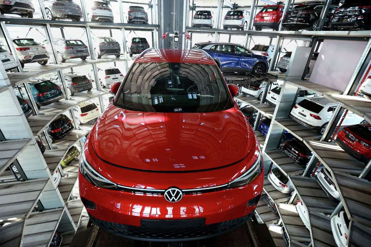 Volkswagen ID. 4 electric vehicles being maneuvered into storage bays in Wolfsburg, Germany.