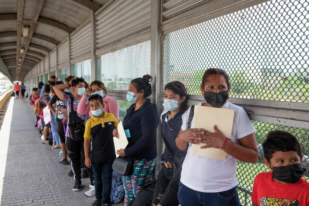 Ana Maria Alvarado and her 9-year-old son Kevin Alexander Avila, from El Salvador, wait with a group who may qualify for a humanitarian exception to enter the U.S., at at the border crossing between Reynosa, Mexico and Hidalgo, Texas, May 1, 2022. At that time, the United States had just started to allow people to apply for asylum under a new process that the secretary of homeland security hoped could help fix the current 'very broken' system.