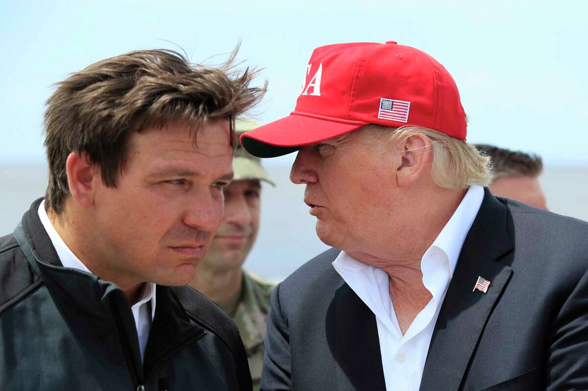 FILE - President Donald Trump talks to Florida Gov. Ron DeSantis, left, during a visit to Lake Okeechobee and Herbert Hoover Dike at Canal Point, Fla., March 29, 2019. Allies of former President Donald Trump have filed a complaint with the Florida Commission on Ethics accusing the state’s governor, Ron DeSantis, of violating campaign finance and ethics rules by running a shadow campaign for president. The complaint was filed Wednesday by MAGA, Inc.