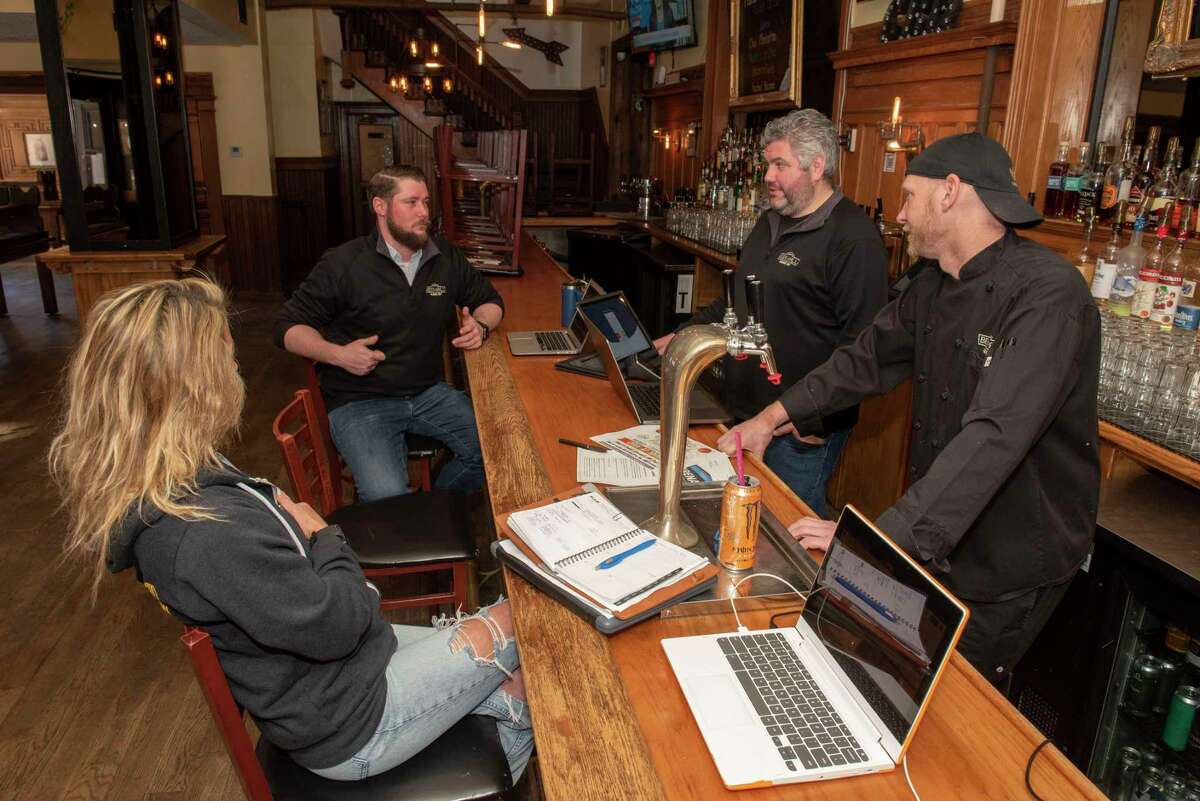 From left, City Beer Hall employees Courtney Panza,Trevor Faulkner, Kurtis Breed and Carl Lichtel hold a meeting at the restaurant as they plan for handling crowds this weekend from the NCAA basketball tournament being held at MVP Arena. Not normally open for lunch on Friday, The City Beer Hall will serve starting at noon on Friday this week for fans going to the 2 p.m. game at the arena. Beer orders included cans and bottles of brews more mainstream than the craft beer regularly featured at the restaurant.