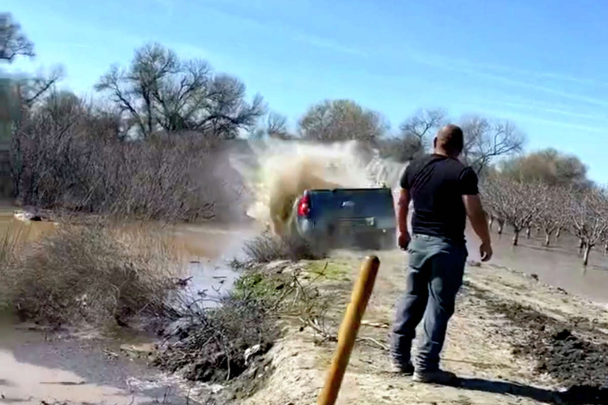 This is a screenshot of a video that began circulating on Twitter on Tuesday, showing people identified as Central Valley farmers driving a truck into a breached levee in an effort to stop floodwaters from the recent storms from inundating land.