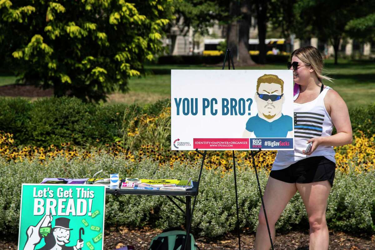 A student from the University of Iowa chapter of Turning Point USA hands out information about their group in 2020.