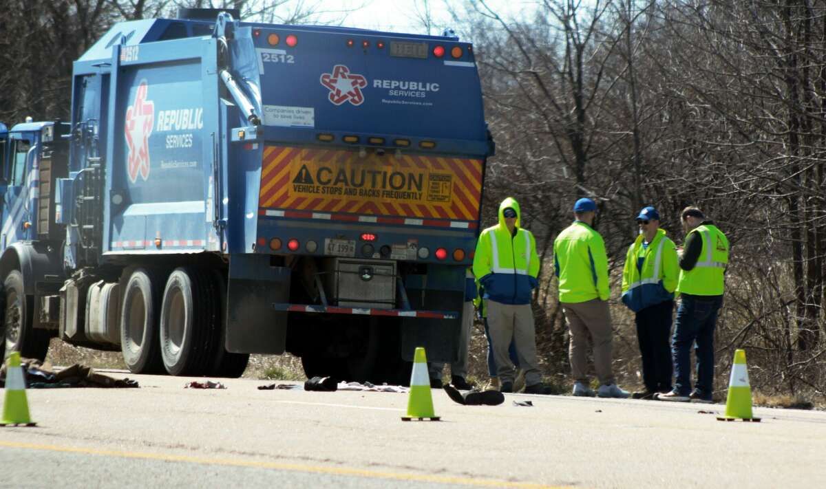 People talk Wednesday at the site where a trash truck was hit by a pedestrian on the SIU Northern Access Road just north of New Poag Road on the northern side of the Southern Illinois University Edwardsville campus.