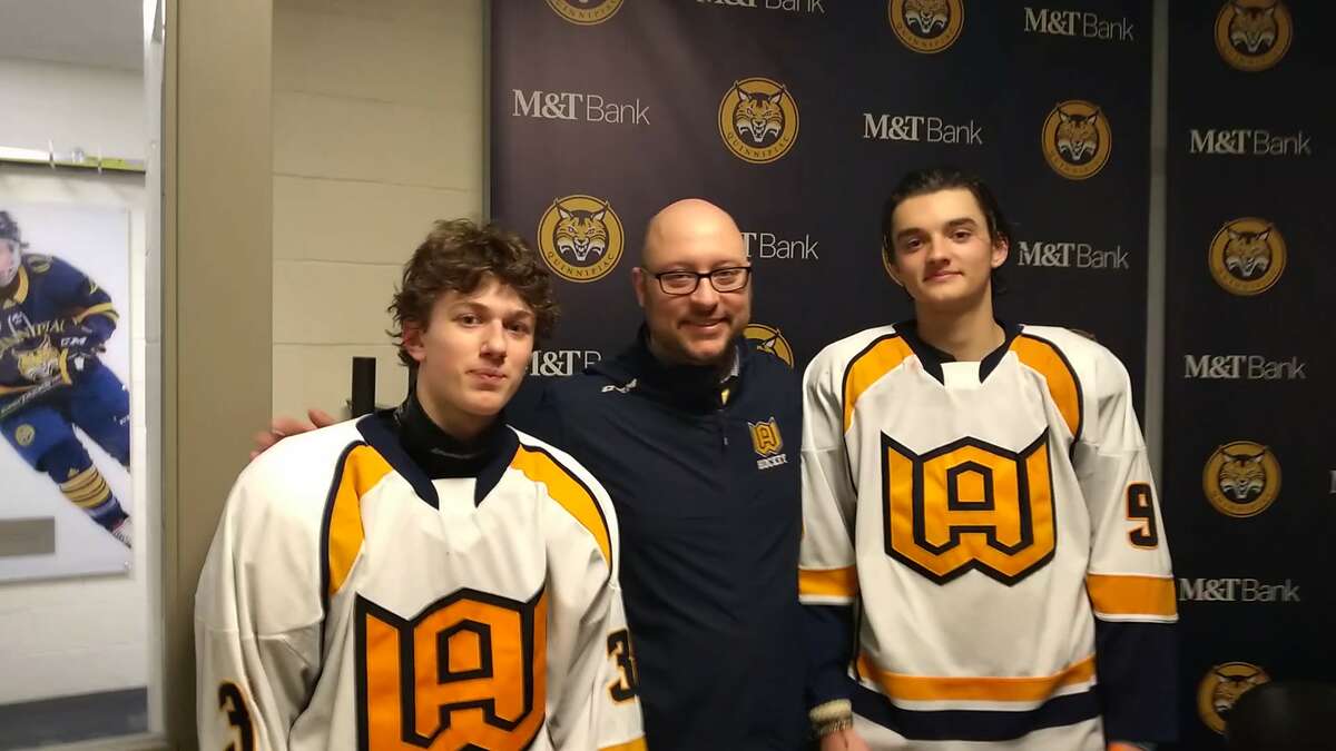 Woodstock Academy players Maxx Corradi, left, and Noah Sampson flank coach Mark Smolak after the Centaurs' 8-5 win over Branford in the CIAC boys hockey semifinals at M&T Bank Arena on March 15, 2023.