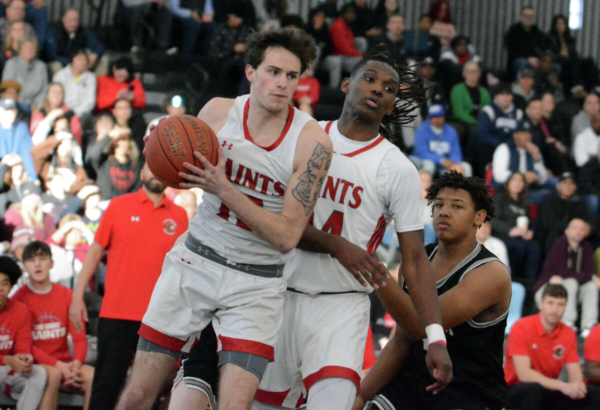 Alex Johnson of St. Bernard controls the ball after pulling down a rebound. Amare Marshall looks on during the CIAC Division II semifinals at Floyd Little Athletic Center in New Haven Wednesday.