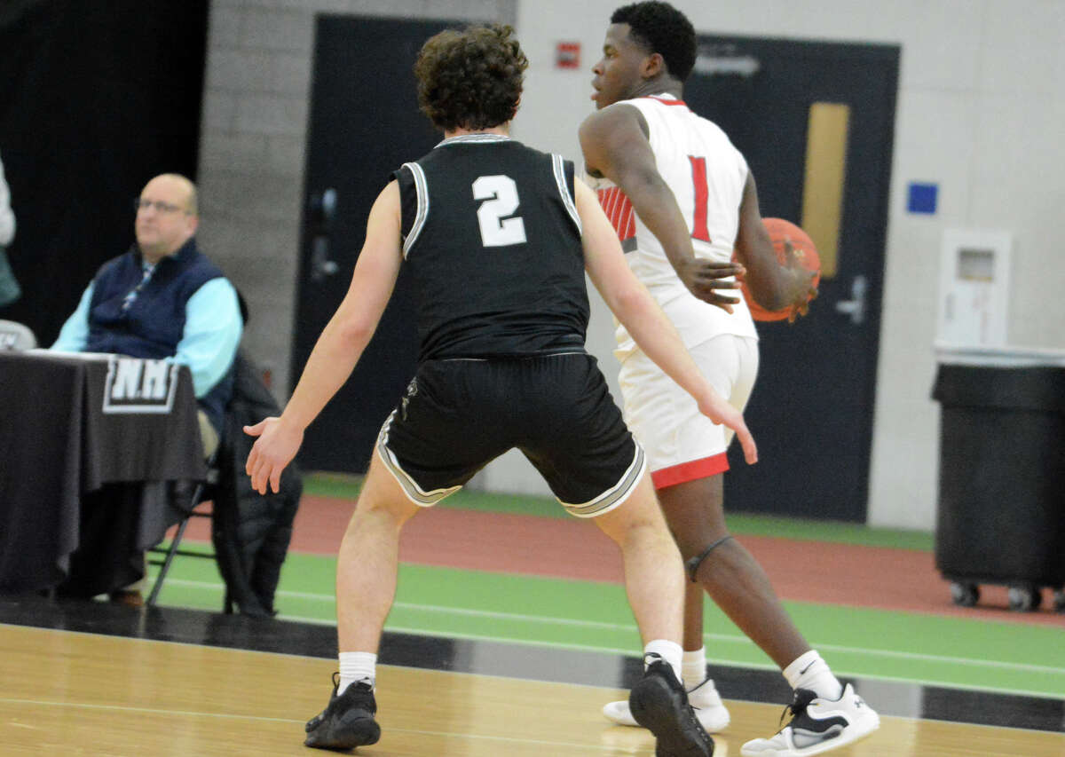 Cedrick Smilllen of St. Bernard looks for a teammate to pass the ball to while being guarded by Matthew Bellavance of Xavier during the CIAC Division II semifinals at Floyd Little Athletic Center in New Haven Wednesday.
