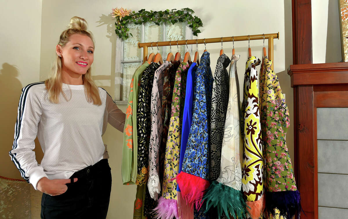 Clothing designer Ashley Alt poses with some of her creations at her home in Ridgefield, Conn., on Wednesday March 15, 2023. The brand is called Valt. Alt's fashionable bathrobes and other types of robe wear are custom made.