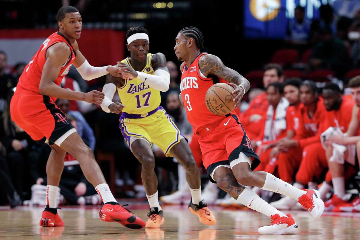 Houston Rockets guard Kevin Porter Jr. (3) drives to the basket past Los Angeles Lakers guard Dennis Schroder (17) as Jabari Smith Jr., left, looks on during the first half of an NBA basketball game Wednesday, March 15, 2023, in Houston.