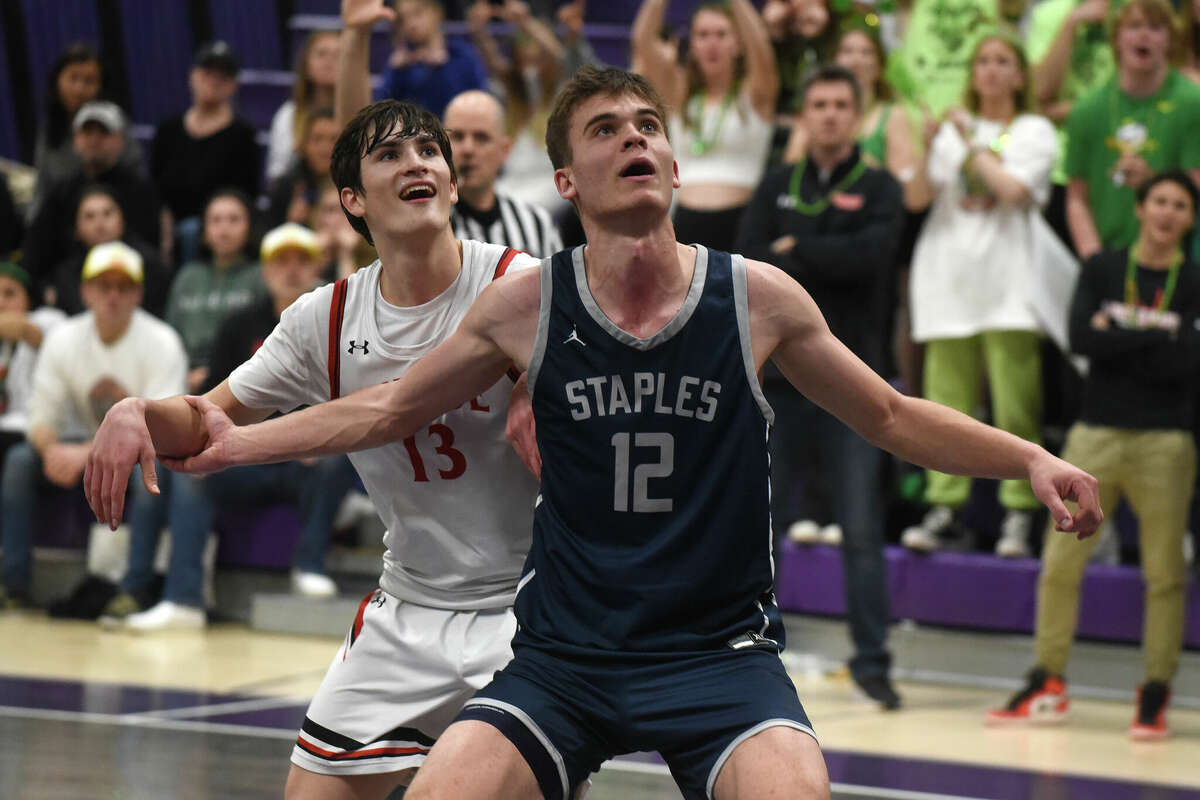 Staples' Chris Zajac (12) and Warde's Jack Plesser (13) battle for position during the CIAC Div. II boys basketball semifinals at Westhill on Wednesday, March 15, 2023.