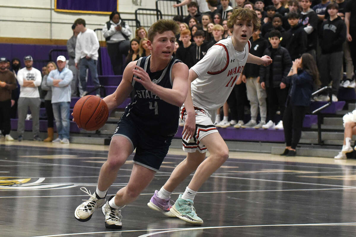 Staples' Cody Sale (4) drives past Warde's Colin Vigeant (11) during the CIAC Div. II boys basketball semifinals at Westhill on Wednesday, March 15, 2023.