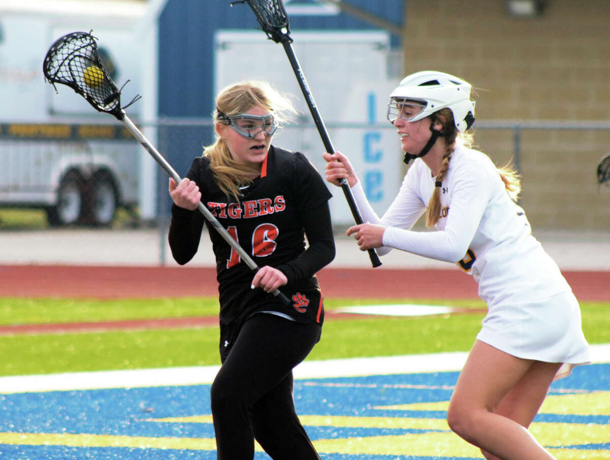 Edwardsville senior Reese Noll looks to pass during the Tigers' 20-4 loss to O'Fallon in the program's first-ever IHSA lacrosse game on Wednesday. Noll scored four gaols for EHS. 