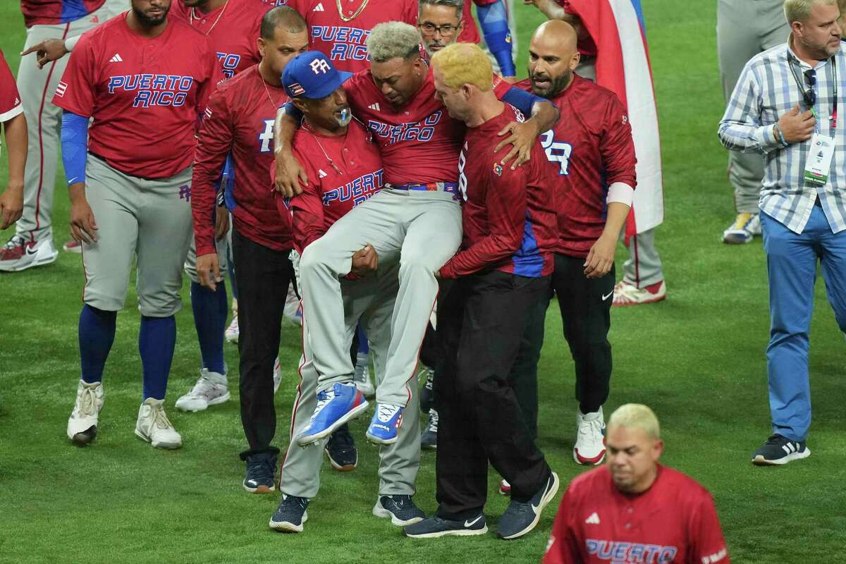 New York Mets reliever Edwin Díaz of Puerto Rico is helped off the field after being injured during the on-field celebration after Puerto Rico defeated the Dominican Republic during the World Baseball Classic in Miami, Fla., on Wednesday.