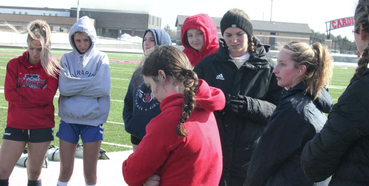 Big Rapids' girls soccer team gathers together in a prepractice huddle on Wednesday, March 15, at Cardinal Stadium.