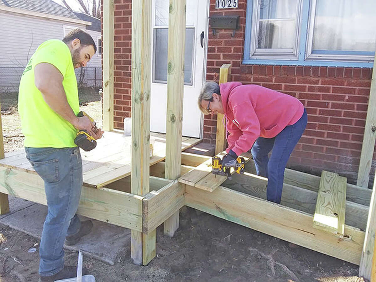 Volunteers with Rebuilding Together Southwest Illinois work at a home in Madison. The group recently finished building a wheelchair ramp at this house, allowing the homeowner to get out of her house without being carried for the first time in almost a year.