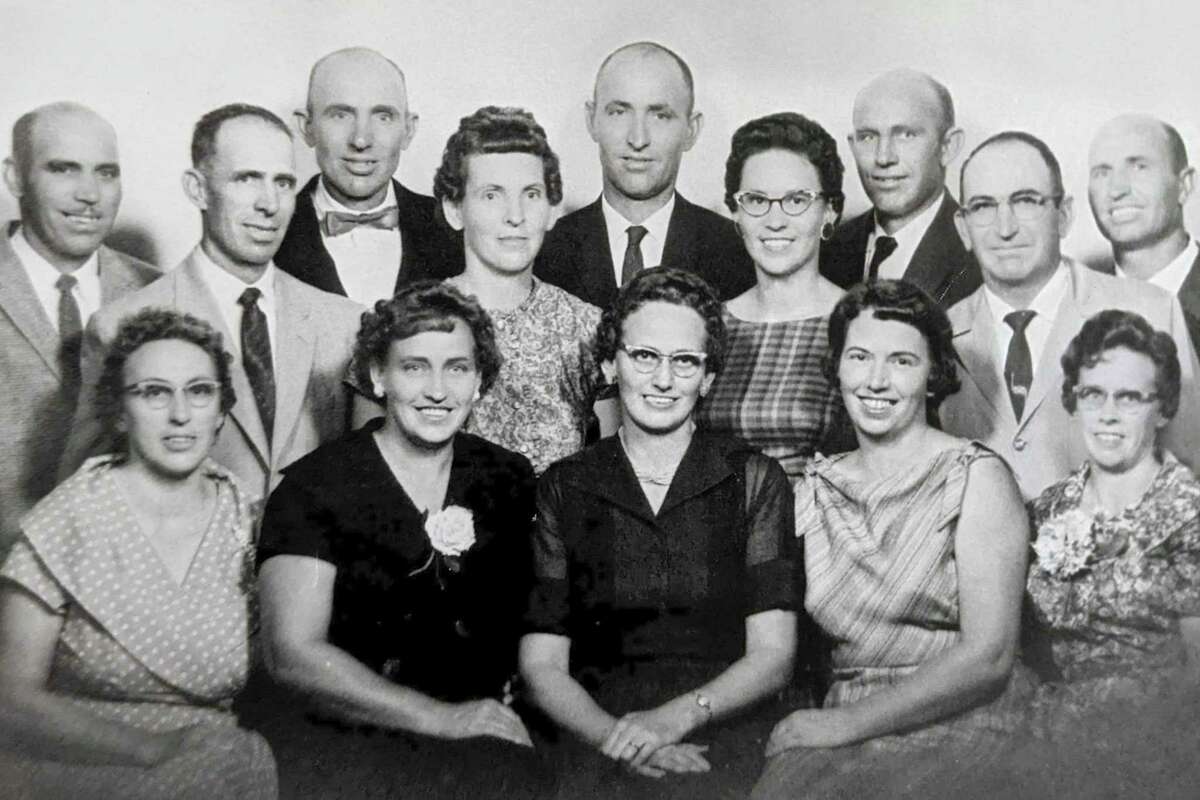 In this photo provided by the family, Doug Whitney's mother, Mildred Reiswig Whitney, back row fourth from left, stands with her siblings during a family reunion in 1959. Doug Whitney’s grandparents had 14 children and 10 of them developed early-onset Alzheimer’s, including his mother. (Courtesy of Ione and Douglas Whitney via AP)