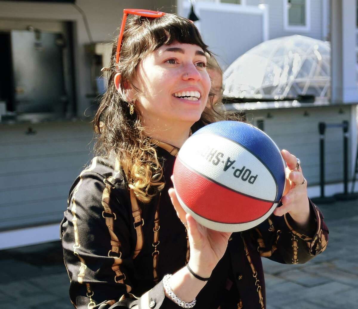 Haddad & Partners Director of Operations Nicole Valentine plays a game of pop a shot basketball during a celebration of the digital creative agency's 16th anniversary at Dockside Brewery in Milford, Conn on Thursday, March 16, 2023.