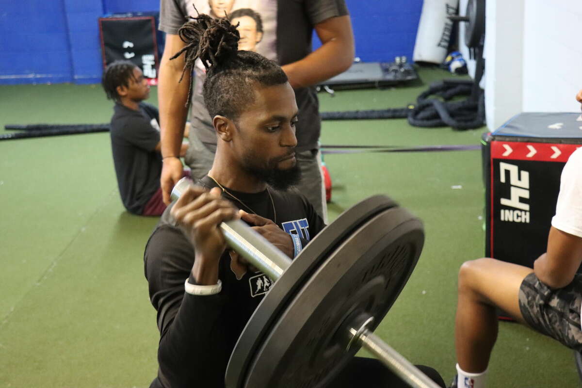 Aaron Garrett, owner and head trainer of 409 Fit in Silsbee, demonstrates how to work the deltoid using a barbell on Thursday, March 16, 2023.