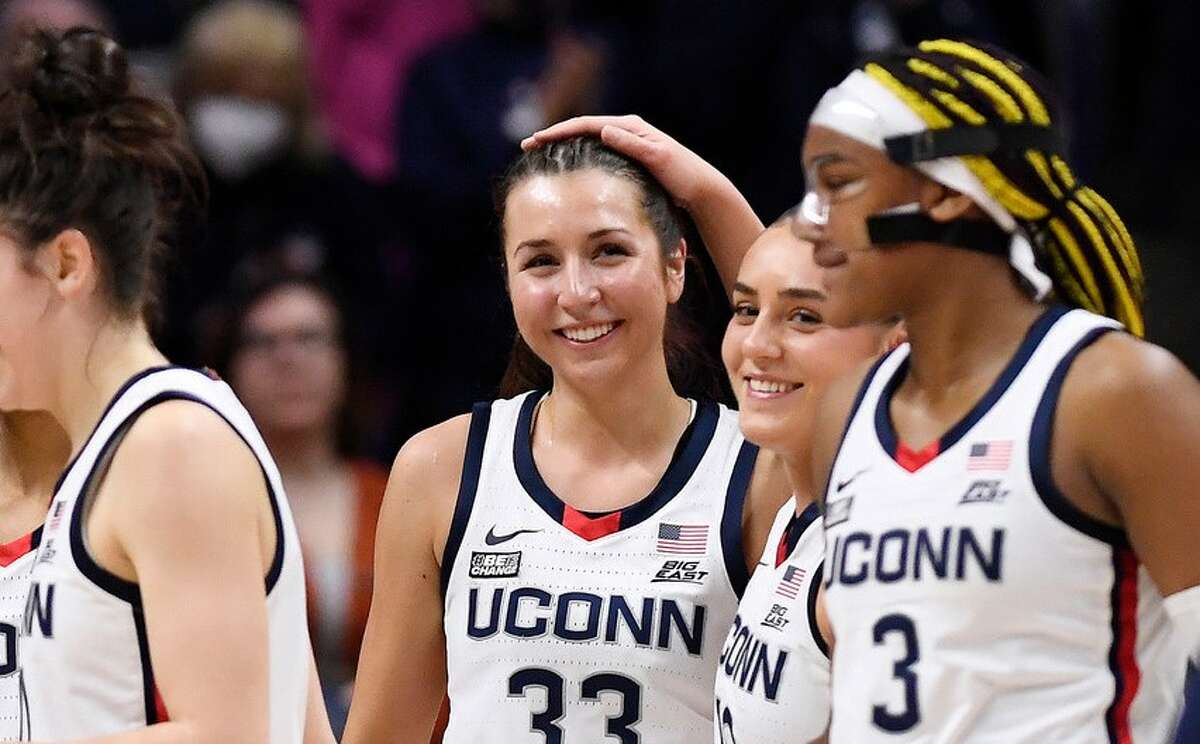 UConn's Nika Muhl (10) pats the head of teammate Caroline Ducharme (33) after Muhl broke the all time season assist record with a pass to Ducharme in the first half of an NCAA college basketball game, Monday, Feb. 27, 2023, in Storrs, Conn. (AP Photo/Jessica Hill)