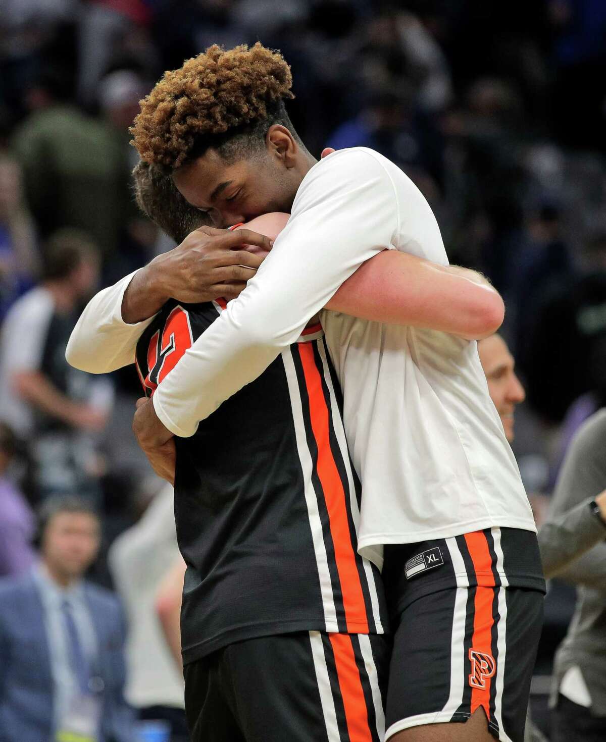 Princeton's Vernon Collins (33) hugs Caden Pierce (12) after the Tigers defeated Arizona   59-55 in the first round 2023 NCAA Men’s Basketball tournament at Golden 1 Center in Sacramento.