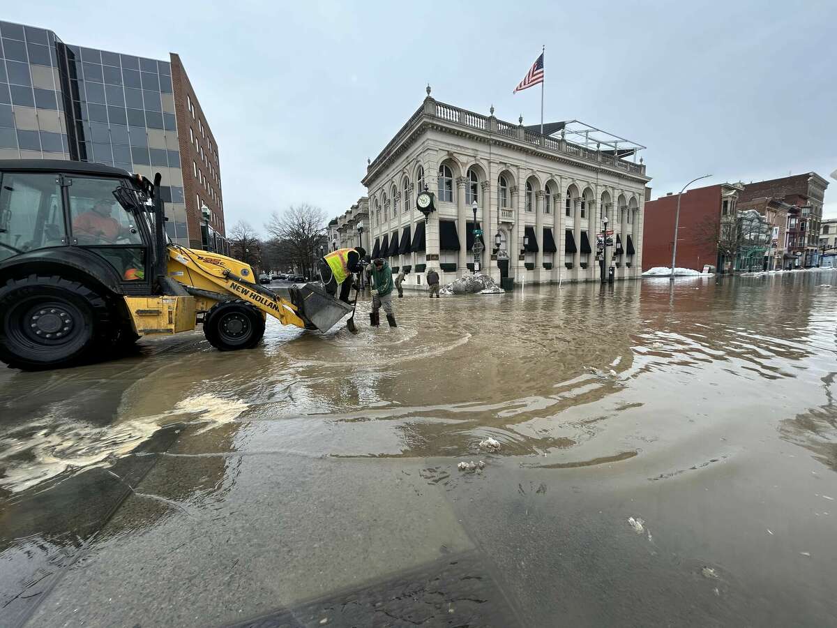 City crews work to clean out drains after water flooded streets in Troy around 4th and Federal streets Friday, March 17, 2023 following a water main break.