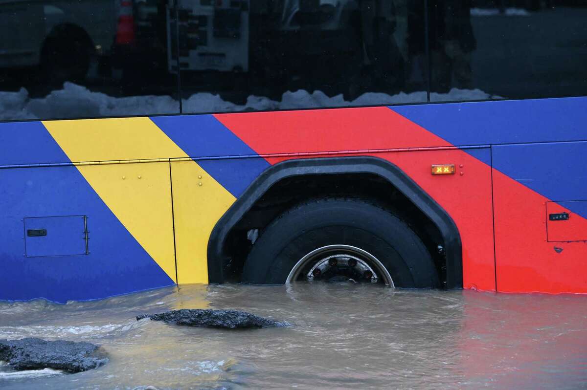A CDTA bus is submerged up to its rear axle after a water main broke at the intersection of Fourth and Federal streets on Friday, March 17, 2023, in Troy, N.Y.