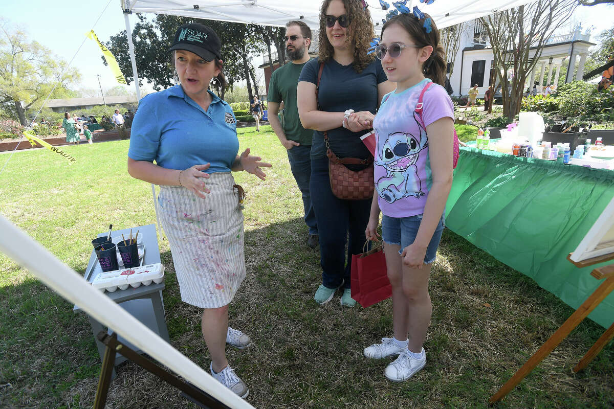 Sophia Bouey helps Heather and daughter Peyton Atkeson get ready to join in the painting station during the first of the McFaddin-Ward House Museum's month-long SOAR events. Photo made Saturday, March 4, 2023 Kim Brent/Beaumont Enterprise