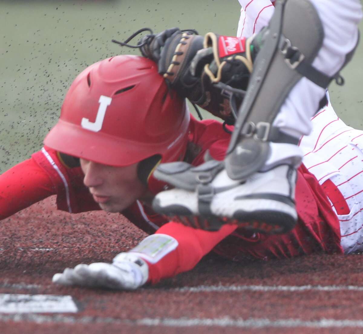 Jacksonville's Anderson Decker is tagged out at home plate during the Crimsons' win over Macomb on Wednesday at Future Champions Sports Complex in Jacksonville.