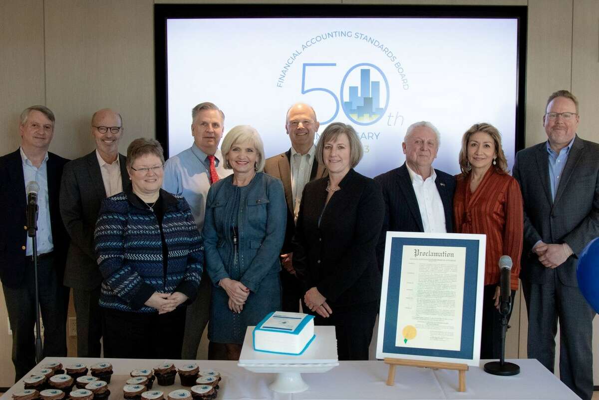 Norwalk Mayor Harry Rilling (back row, third from right), Lucia Rilling (back row, second from right) and Greater Norwalk Chamber of Commerce President Brian Griffin (back row, far right) present the members of the Financial Accounting Standards Board with a special proclamation to commemorate the 50th anniversary of the board’s first meeting. Ceremony attendees also include (from left) Financial Accounting Foundation Executive Director John Auchincloss, FASB member Fred Cannon, FASB member Marsha Hunt, FASB Vice Chair Jim Kroeker, FASB member Christine Botosan, FASB Chair Rich Jones, and FASB member Sue Cosper.