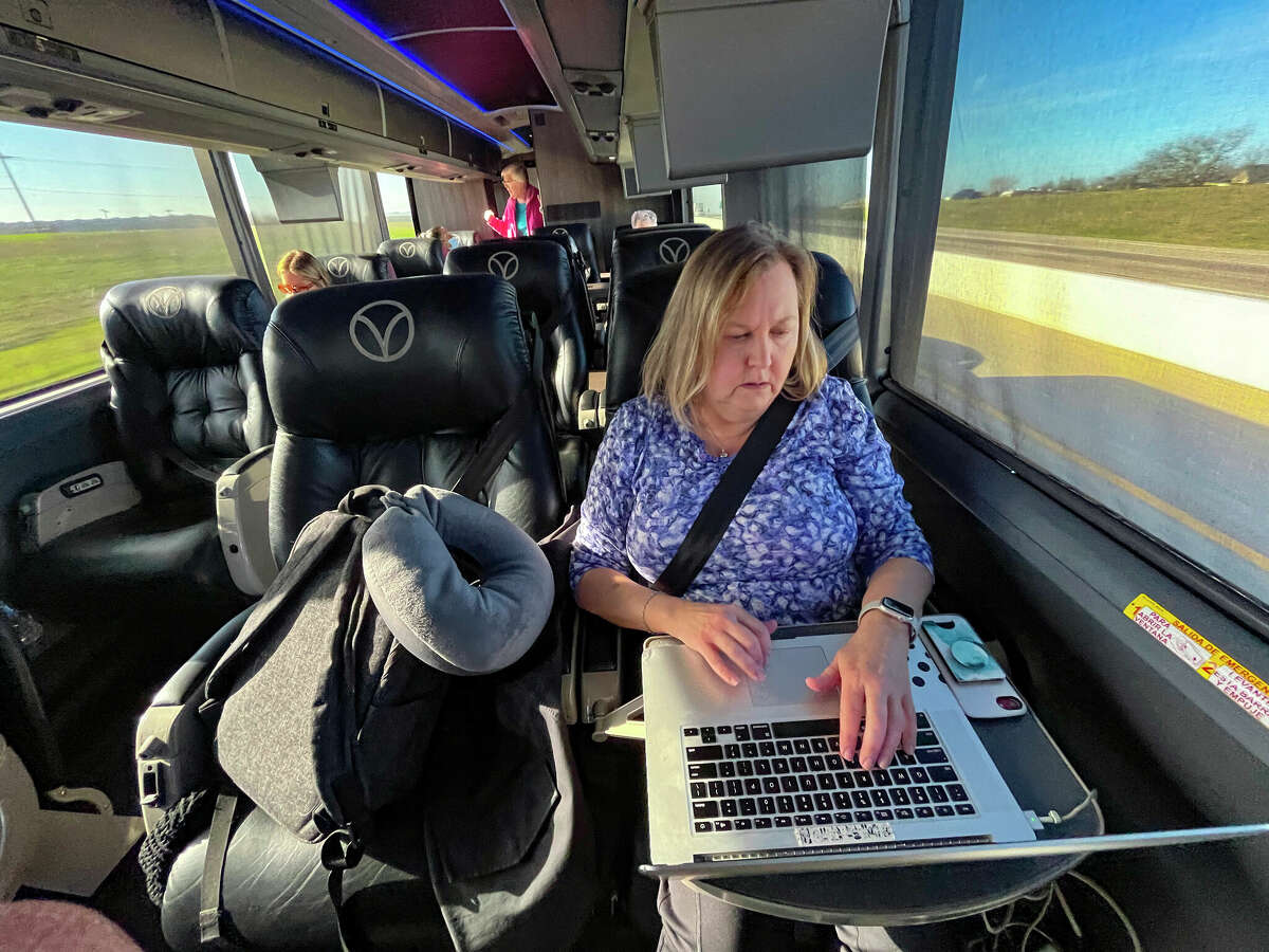 Each seat has its own tray table, task light and power outlet. Here, passenger Karen Miller works on her computer on the drive to Dallas.