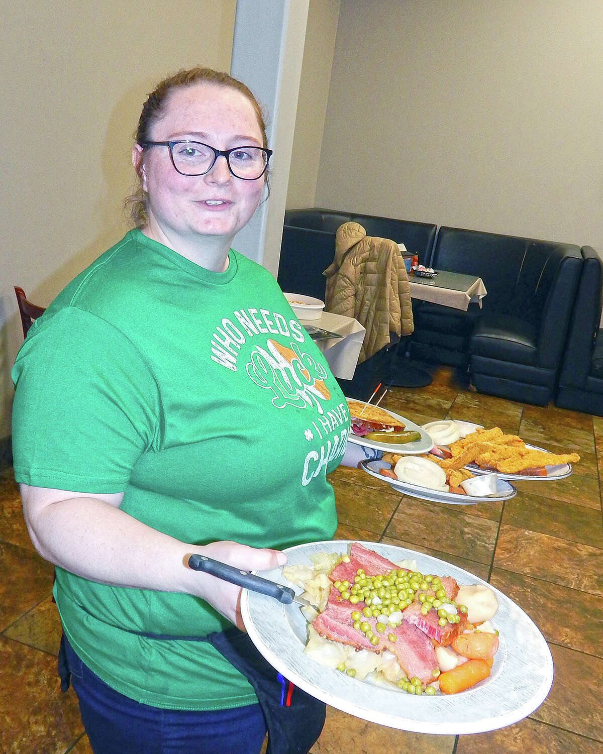 Kirsten Woods, manager at Rudi's Grill, prepares to serve a plate of corned beef and cabbage during lunch rush at the Morton Avenue restaurant. The dish was the day's special Friday, in recognition of St. Patrick's Day.