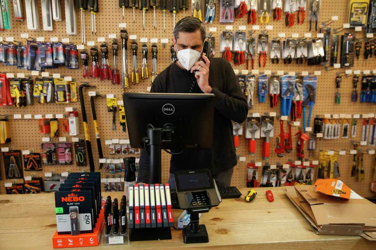 Owner Karl Aguilar answers a customer’s question on the phone at Papenhausen Hardware in San Francisco. The store has been struggling to regain customers since the pandemic began.
