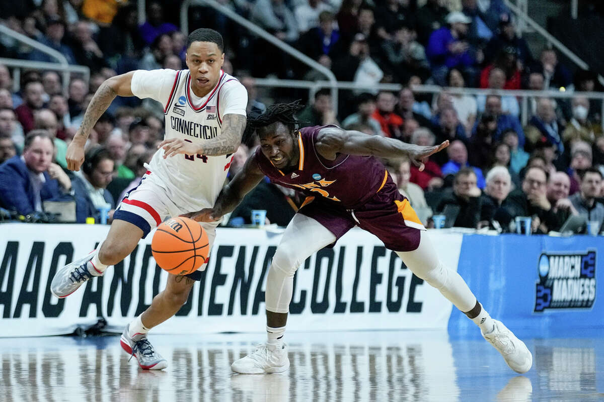 Connecticut's Jordan Hawkins (24) and Iona's Sadiku Ibine Ayo (2) chase a loose ball in the first half of a first-round college basketball game in the NCAA Tournament, Friday, March 17, 2023, in Albany, N.Y. (AP Photo/John Minchillo)