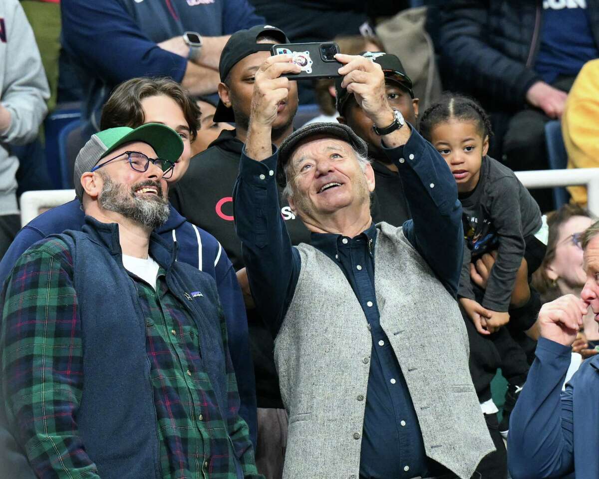 Actor Bill Murray takes a selfie with fans during the first round of the NCAA tournament featuring UConn and Iona on Friday, March 17, 2023, at the MVP Arena in Albany, NY.
