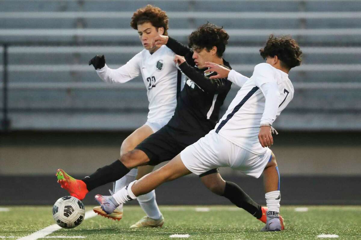 Conroe's Axel Lopez (21) battles for the ball between College Park's Austin Schipper (22) and Alejandro Escobar (7) during the first half of a District 13-6A high school soccer match at Conroe High School, Friday, March 17, 2023, in Conroe.
