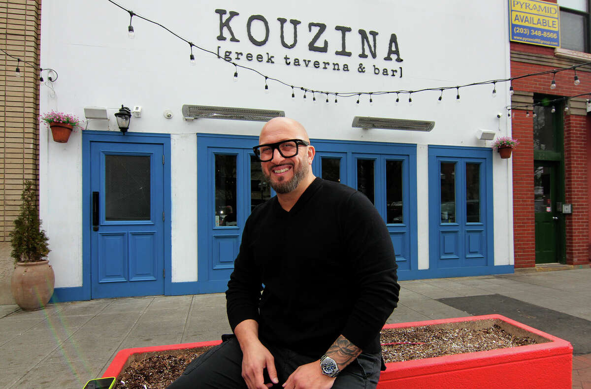 Kouzina Greek Taverna and Bar owner Peter Valis poses in front of the restaurant along Main Street in Stamford, Conn., on Friday March 17, 2023. Outdoor dining on Main Street was a game-changer for Kouzina and the other businesses there. The city put solid barriers in the road and they used all the parking spaces, it was a new little walking district. They're a relatively small restaurant, but they had 60+ seats, which he said was a "lifeline."