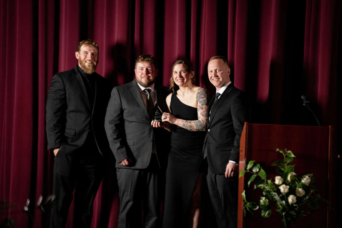 (From left) Mason and Matt Swidorski and Megan Savela, of Swidorski Bros. Excavating LLC, accept the Small Business of the Year award from presenter Kenny Kott on March 10 during the Manistee Area Chamber of Commerce's annual awards gala.