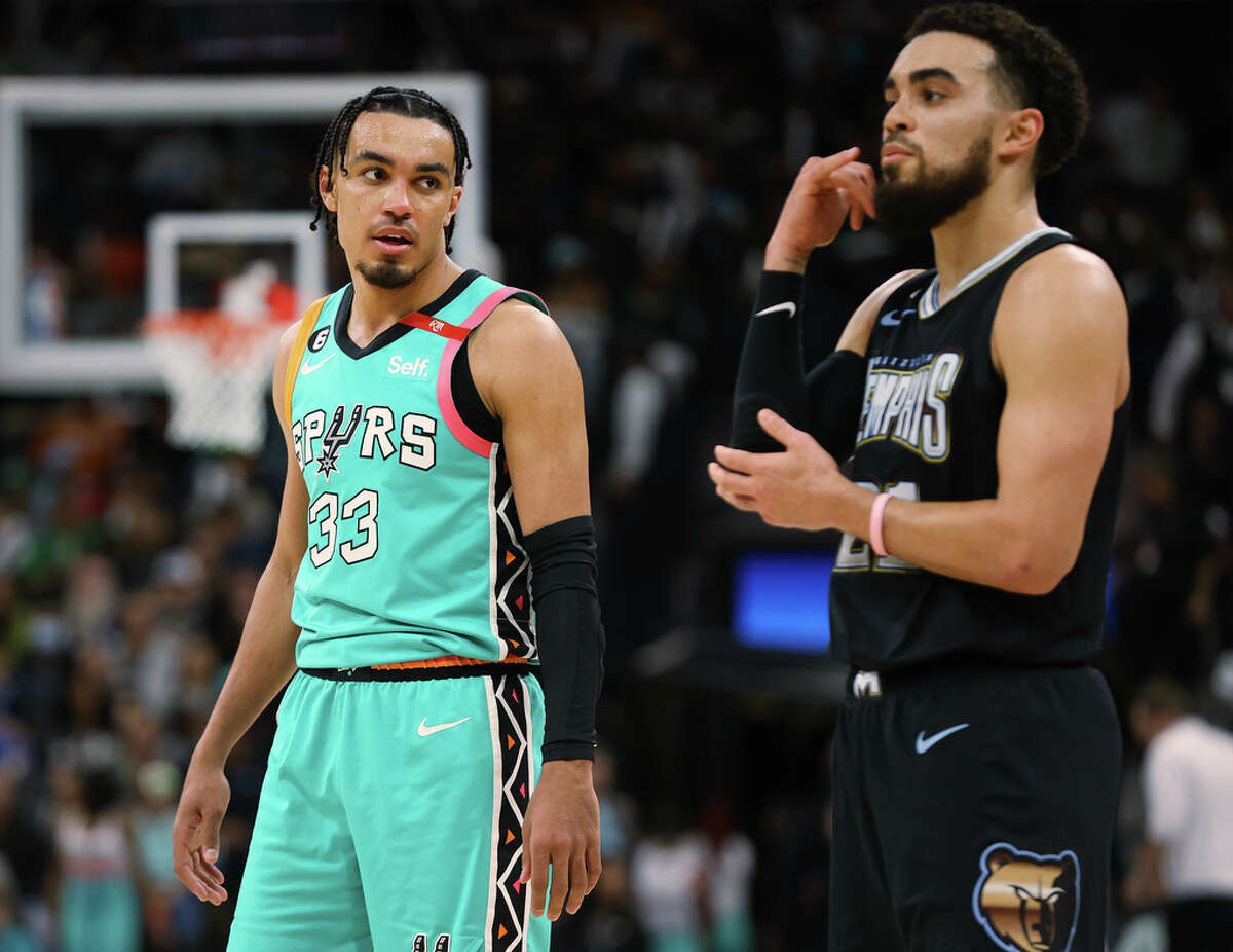 Spurs’ Tre Jones (33) looks over at his older brother and Memphis Grizzlie Tyus Jones (21) at the AT&T Center on Friday, Mar. 17, 2023. Spurs lose to the Grizzlies, 126-120, in overtime.