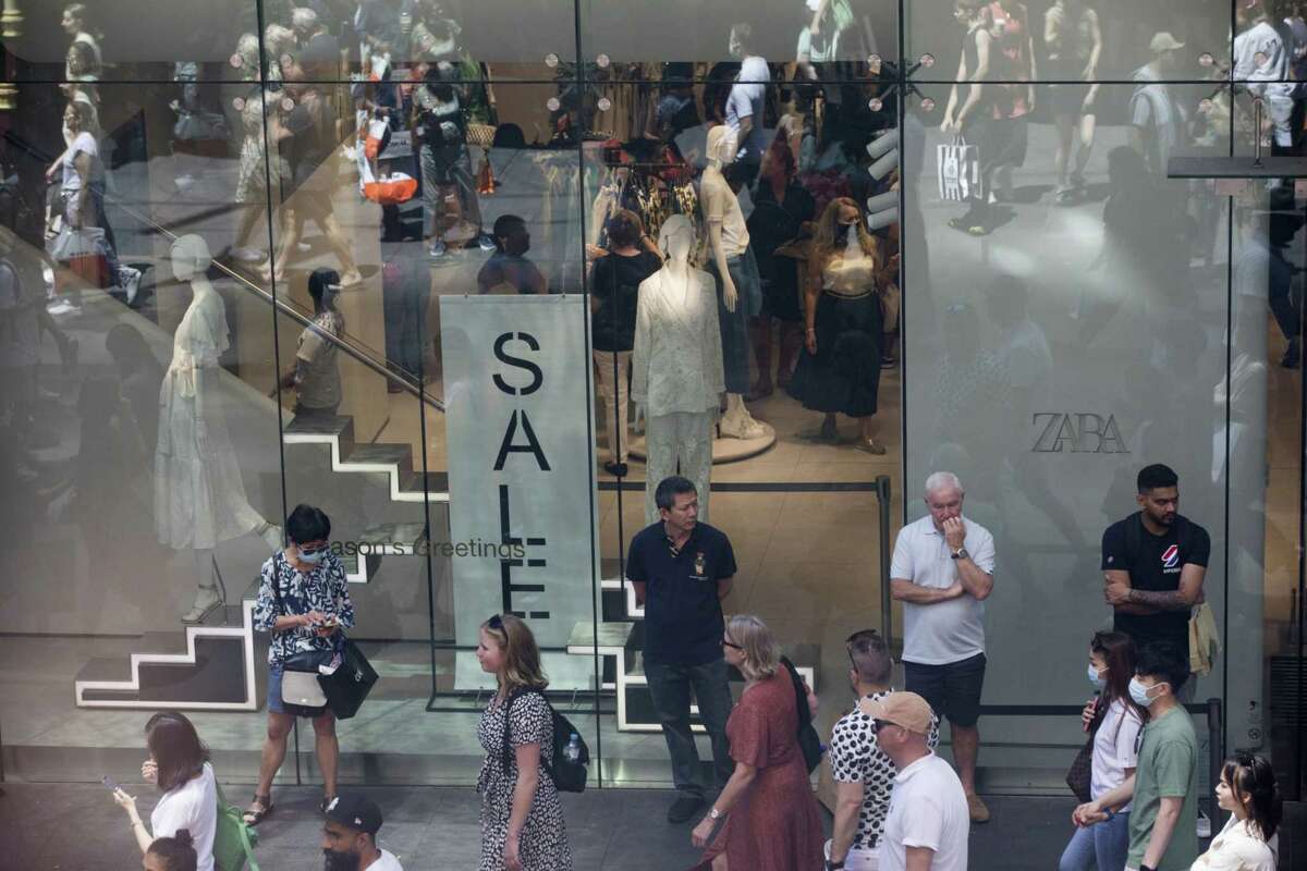 People stand outside a Zara store at Pitt Street Mall in Sydney, New South Wales, Australia, on Monday, Dec. 26, 2022. Australia's consumer sentiment remained deeply pessimistic and business confidence turned negative for the first time this year as rapid-fire interest rate increases dragged on the economy.
