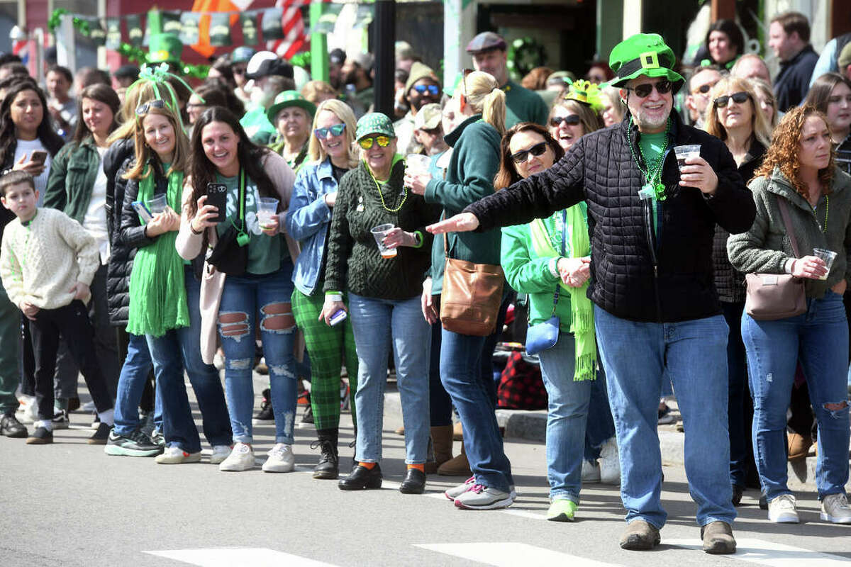 Crowds line up along Fairfield Avenue to watch the Greater Bridgeport St. Patrick’s Day Parade on Friday, during which a female police officer working the parade was hit by an SUV while attempting to cross the street.
