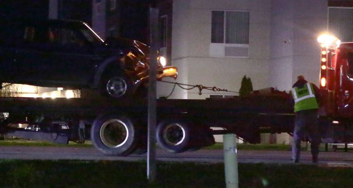 As the vehicle is loaded onto a flatbed for towing, significant damage is obvious to the pickup truck involved in a crash with a police squad car Friday night, March 17, 2023, in Edwardsville.