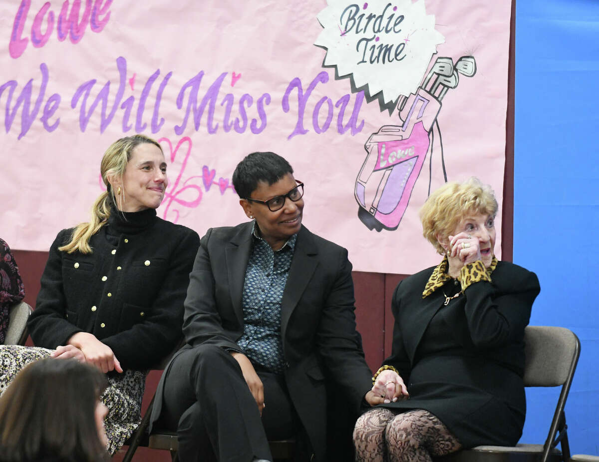 Stamford Mayor Caroline Simmons, left, and Stamford Superintendent of Schools Tamu Lucero, center, congratulate office support specialist Carolyn Lowe during a surprise assembly in celebration of her retirement at Hart Magnet Elementary School in Stamford, Conn., Wednesday, March 1, 2023. After a 37-year career, Lowe received a grand exit with each grade performing original songs, poetry, chants, interviews, and sharing their top reasons for loving Mrs. Lowe.