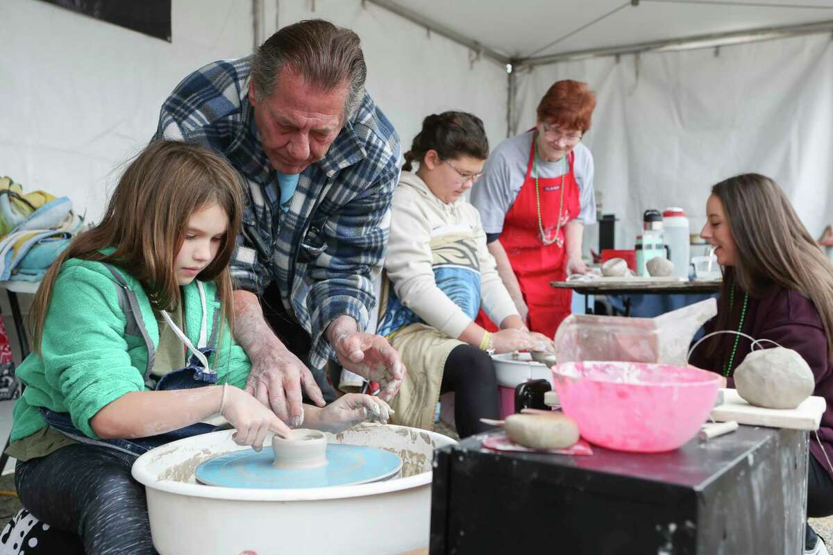 David Sharp helps guide Hadley Preston to shaping a bowl for the nonprofit Empty Bowls during the Greater Conroe Arts Festival, Saturday, March 18, 2023, in Conroe. The organization raises money to fight hunger across communities.
