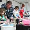 David Sharp helps guide Hadley Preston to shaping a bowl for the nonprofit Empty Bowls during the Greater Conroe Arts Festival, Saturday, March 18, 2023, in Conroe. The organization raises money to fight hunger across communities.