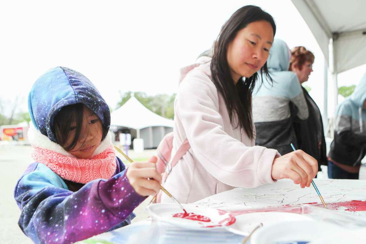Elanor Chan, left, and her mother, Lily, paint part of a community mural from the Greater Conroe Arts Alliance during the Greater Conroe Arts Festival, Saturday, March 18, 2023, in Conroe.