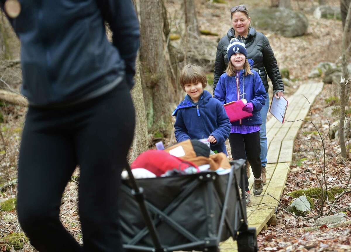 From left; Laurel Scarlata leads Oliver Novak, 5, Colleen Cooper, 8, and Madelyn Jolliffe, all of Greenwich, in a nature walk of Converse Brook Preserve as part of her monthly Greenwich Nature Day immersion program for kindergarten thru fifth graders in Greenwich, Conn on Saturday, March 18, 2023.