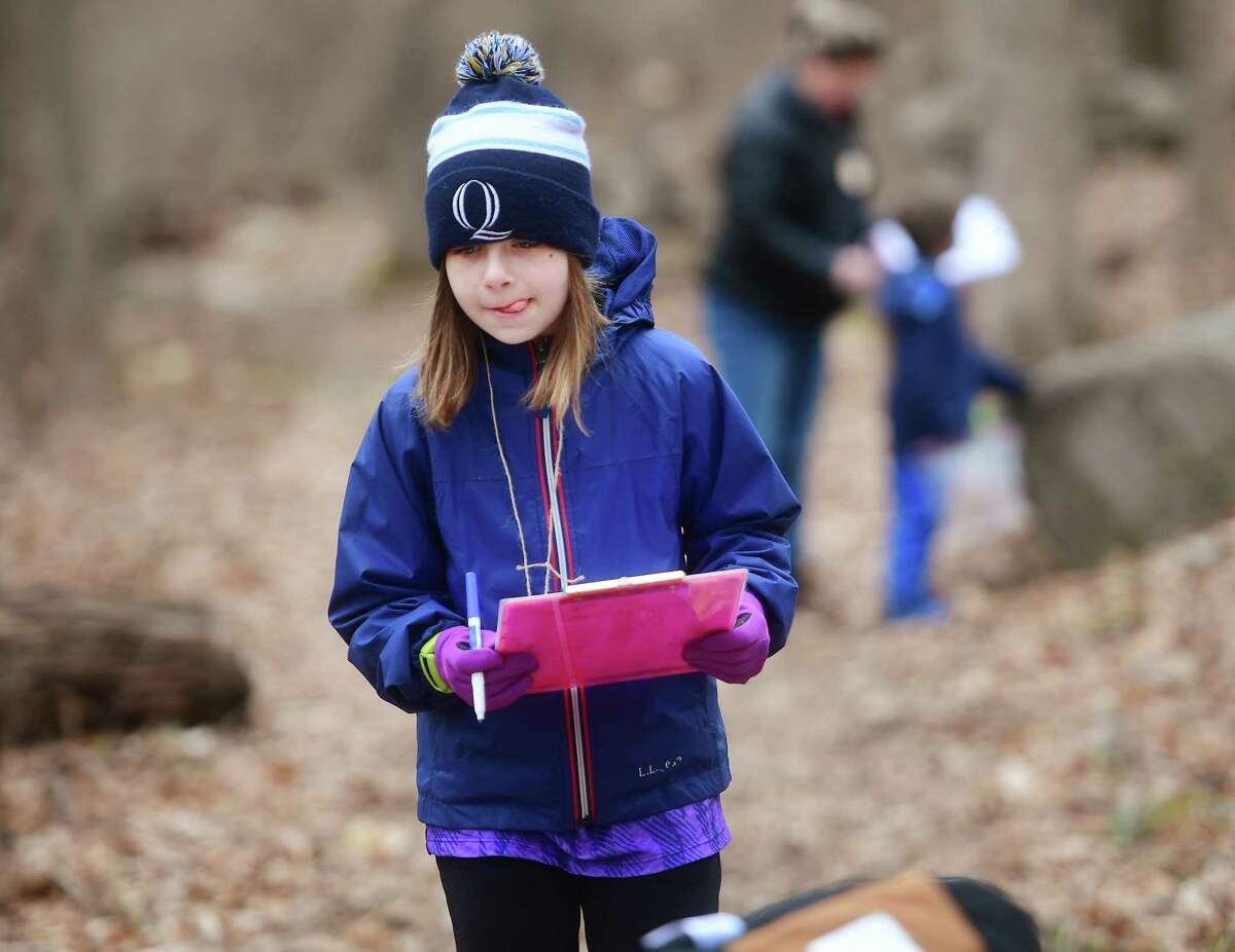 Colleen Cooper, 8, of Greenwich, searches for items on a nature scavenger hunt at Converse Brook Preserve during Laurel Scarlata's monthly Greenwich Nature Day immersion program for kindergarten thru fifth graders in Greenwich, Conn on Saturday, March 18, 2023.