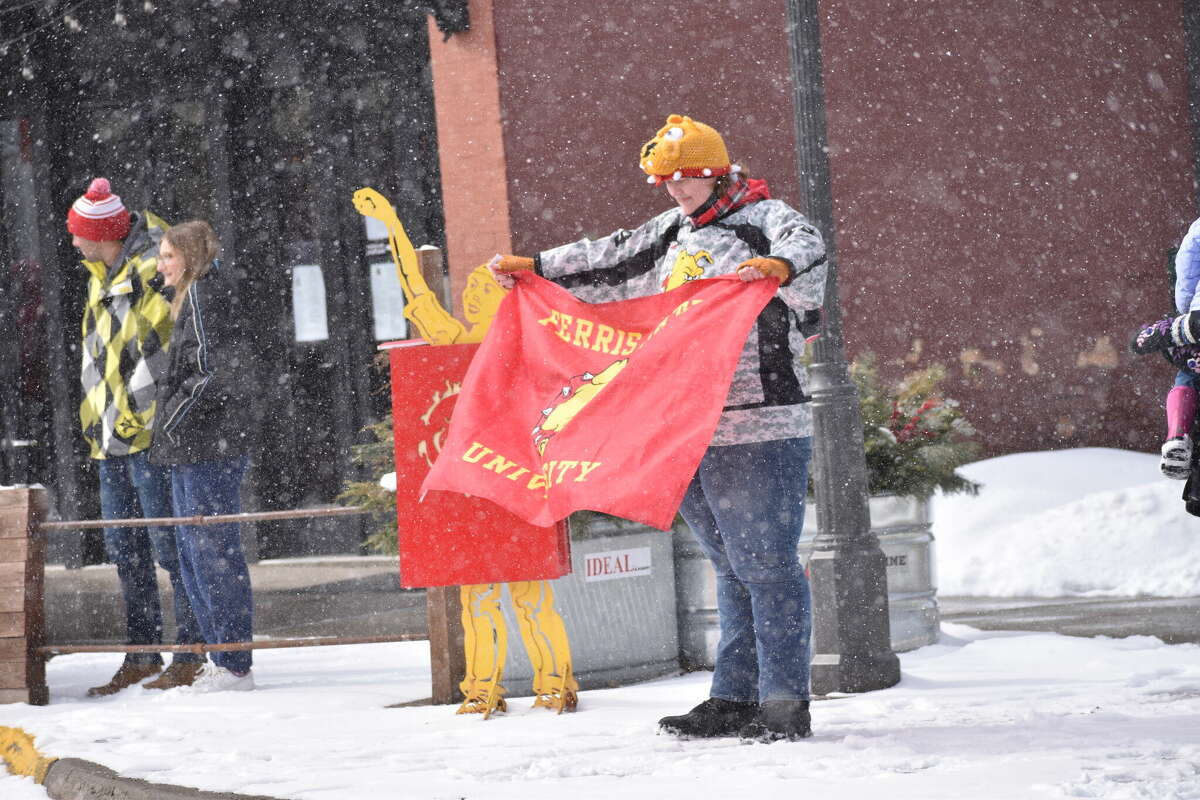 A Ferris State fan celebrates in the snow in downtown Big Rapids.