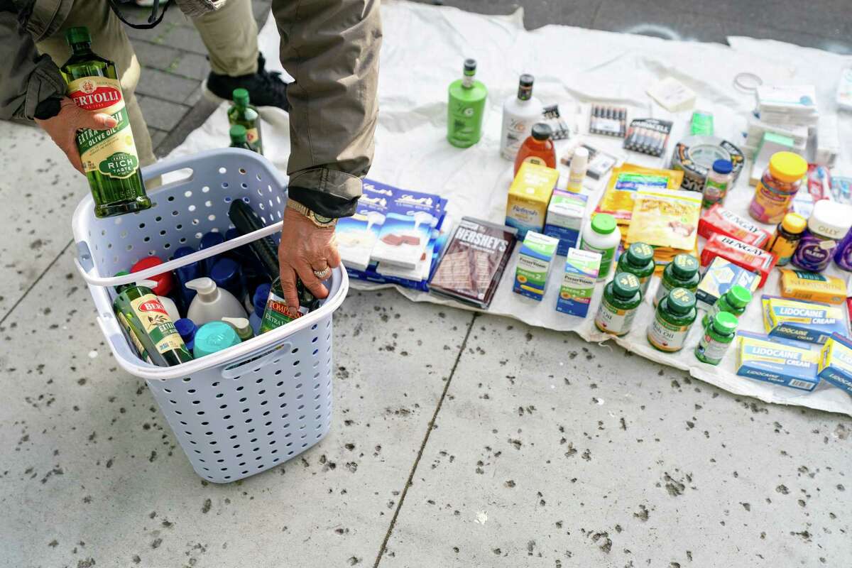 An unlicensed street vendor packages goods after an inspection by a San Francisco Public Works crew.  