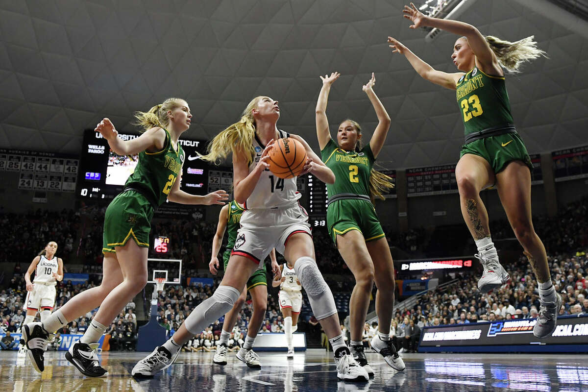 UConn's Dorka Juhasz (14) looks to shoot against Vermont's Anna Olson (24), Vermont's Aryana Dizon (2) and Vermont's Emma Utterback (23) in the first half of a first-round college basketball game in the NCAA Tournament, Saturday, March 18, 2023, in Storrs, Conn. (AP Photo/Jessica Hill)